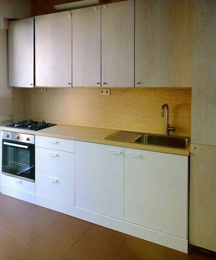 Gerenoveerde witte greeploze keuken met inbouwoven