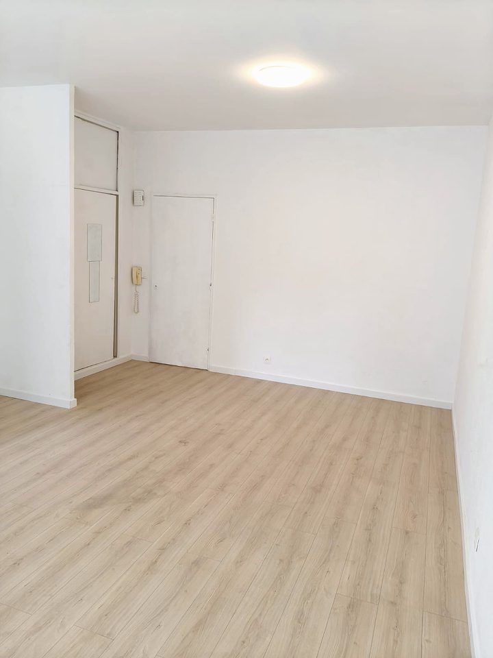 Gerenoveerde lege kamer met laminaatvloer en vers geschilderde muren
