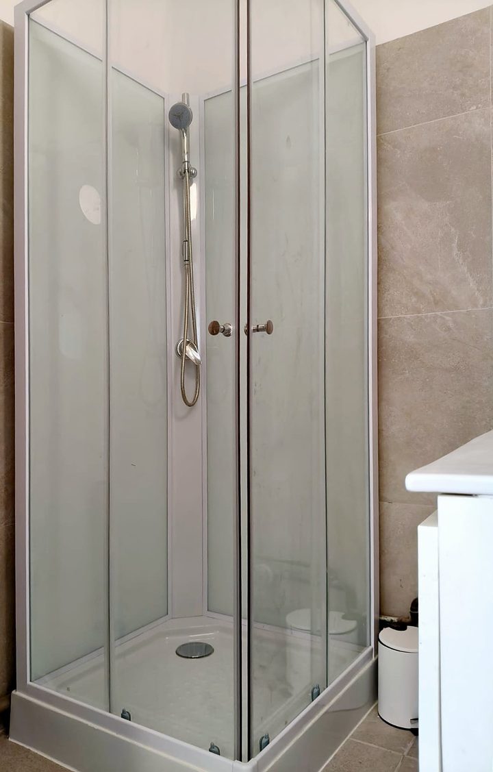 Gerenoveerde douche met glazen cabine en wandtegels